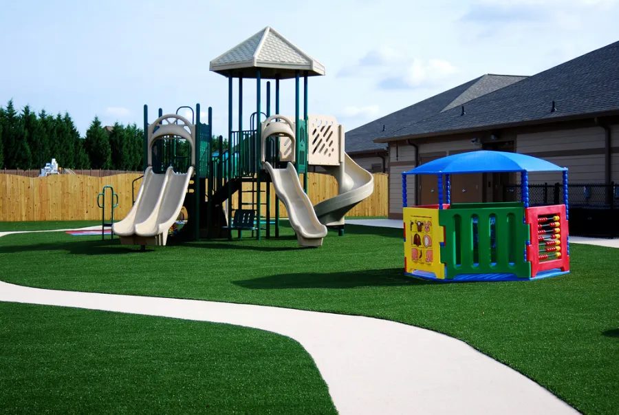 Playground on artificial grass with a walking path
